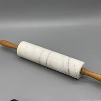 Full view of marble rolling pin showing entire length and both wood handles