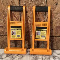 Front view of both orange drywall panel carriers showing handles and labels