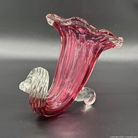 Left side profile showing cranberry body, clear rim and spiral foot