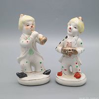 Full view of both porcelain clown figurines on bases