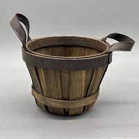 Side view of basket showing wood slats and leather handles