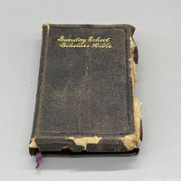 Front view of worn leather Bible with gold title