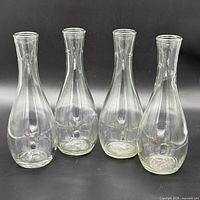 Four clear glass bottles front view
