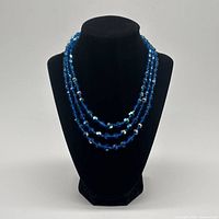 Necklace displayed on bust showing full drape of three strands