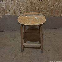 Front view of wooden stool showing wear and structure