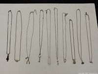 All ten sterling silver necklaces laid out showing full length and pendants