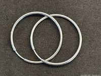 pair of white gold hoop earrings on black background