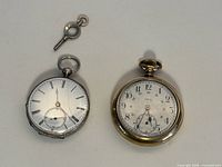 Two pocket watches and winding key layout