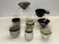 All eight pottery pieces grouped front and back