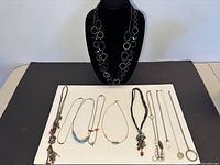 Front view showing all necklaces laid out and statement necklace on bust