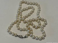Full strand of pearls laid out showing clasp