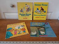 Four children’s books laid out on table