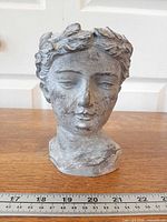 Front view of cement goddess head planter with ruler for scale