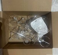 Box containing assorted clear plastic stemware and bag of ring picks