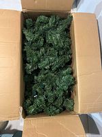 Box containing multiple strands of green pre-lit garland