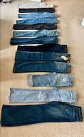 All 13 pairs of jeans laid out in two rows, showing color variety and length