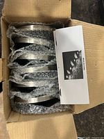 Open box showing several bubble-wrapped solar ground lights and instruction sheet