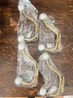Four brass coat hooks in packaging