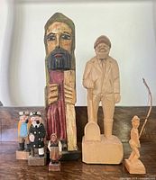 Group shot of all seven carved figures showing size differences