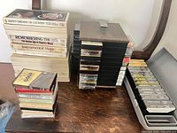 Overview of cassette boxed sets, loose cassettes, vertical rack, grey storage case