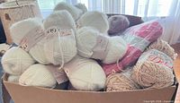 box of cream Magil skeins, pink sealed pack, beige skein