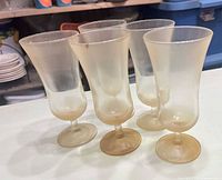 Group of five amber frosted goblets showing color, finish, and foot design
