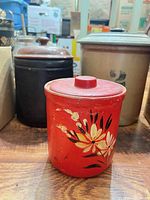 Front view of red floral canister with other two canisters partially visible