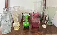 Group shot of twelve assorted bud vases on wooden surface