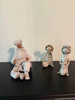 Three glazed ceramic figurines displayed on shelf
