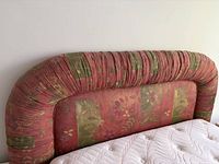 front view of padded floral patchwork headboard attached to bed base