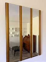 Full view showing four mirror panels with gold dividers