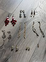 All eight pairs of earrings laid out on wood surface
