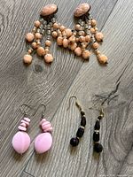 Three pairs of loose earrings: chandelier, pink drops, black drops