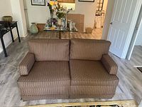 Full front view of striped loveseat in room
