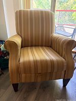 Front view of striped recliner armchair showing upholstery pattern, arms, legs, and recline handle