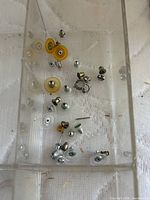 Loose metal earring backings and small studs in tray