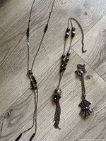 All three necklaces laid out to show length, bead placement, pendants and tassels