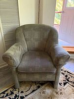 Front view of first green tub armchair showing overall style and condition