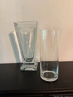 Two clear glass vases, square tapered and cylindrical