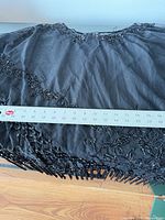 Full cape laid flat with tape measure showing length and bead fringe detail
