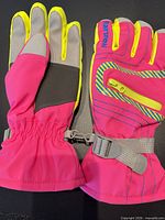 Front view of both gloves showing color, zip pocket, strap, brand logo