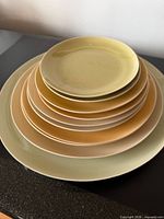 Stack of eleven assorted size plates showing colour range