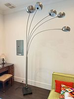 Full view of brushed nickel 5-light arc floor lamp standing in room