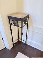 full view of tall black metal plant stand with stone top