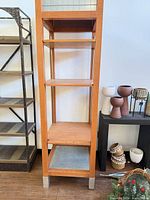 Front view of one display fixture showing shelves, grid accent and feet