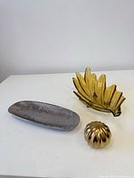 Group shot of amber glass bowl, silver tray, gold orb