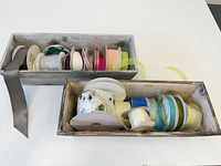 Two wooden planter boxes filled with assorted ribbon spools