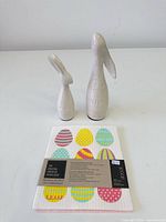 Front view of both rabbit figurines and packaged dishcloth
