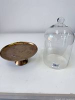 glass cloche and metal stand side by side