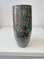 Front view of tall ceramic vase showing mottled green-turquoise glaze